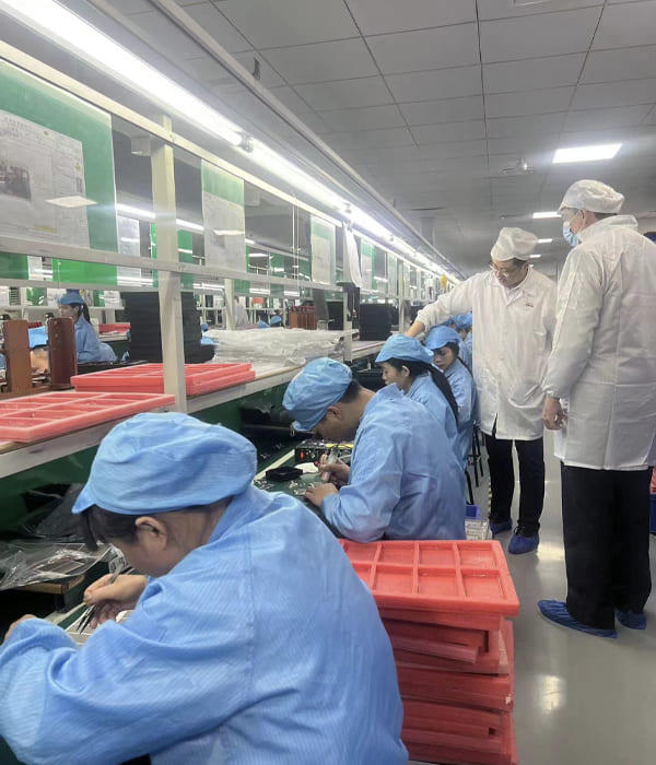 um grupo de pessoas em uma fábrica de smartwatches trabalhando em máquinas.